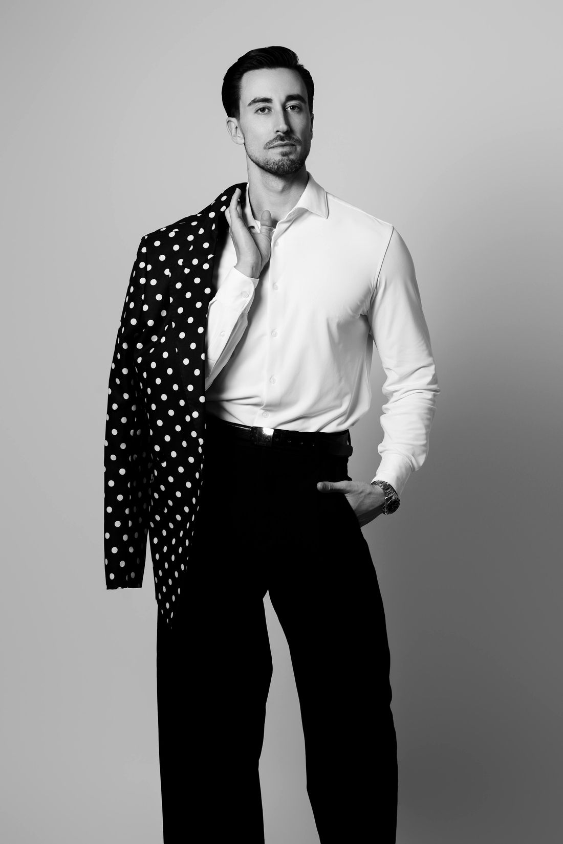 Borja Martínez con camisa blanca y una chaqueta de lunares al hombro
